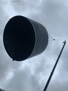 Large rainwater tank being lifted by crane